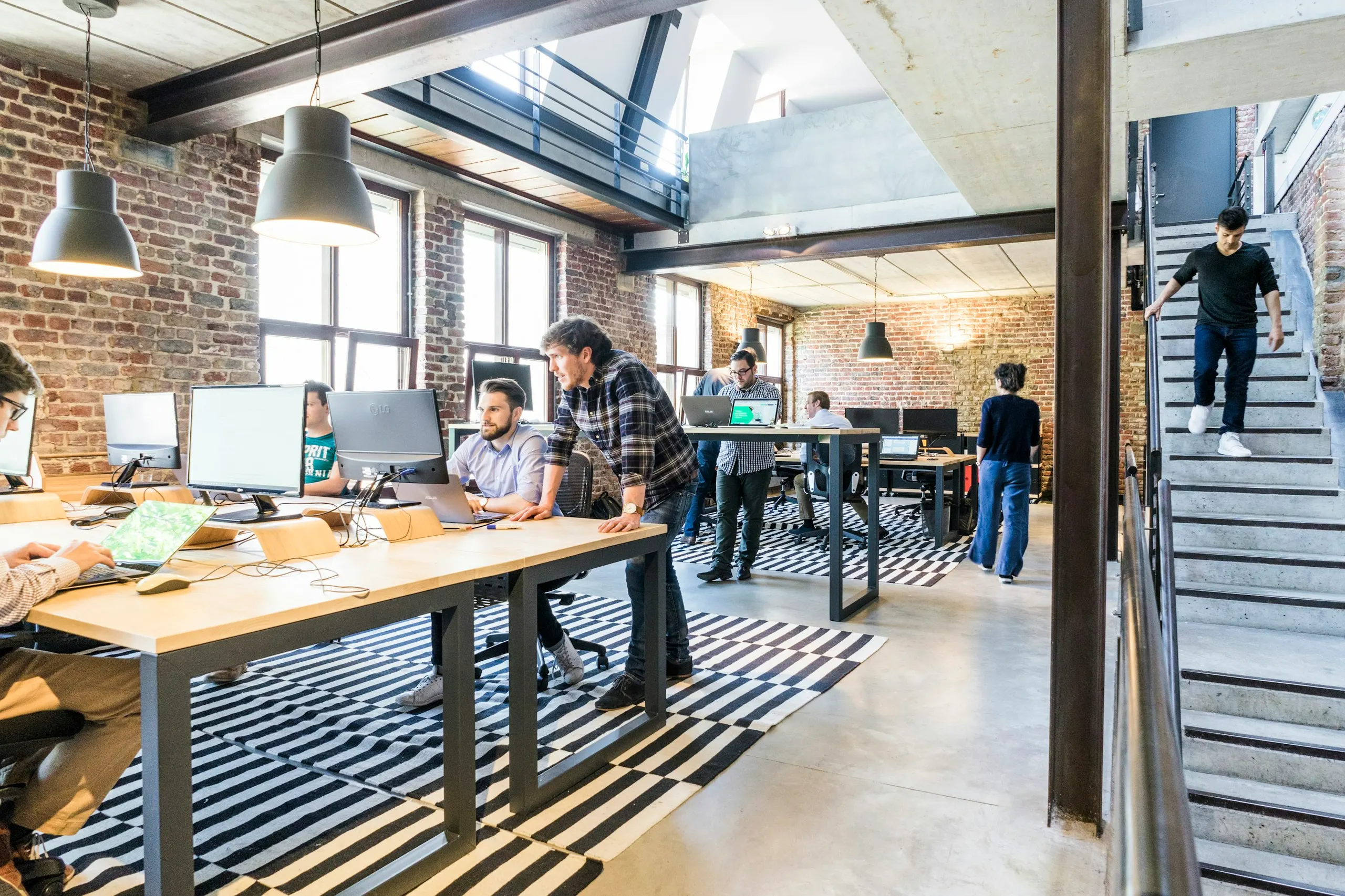 A team collaborating at shared desks in a naturally lit operations office.